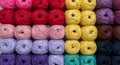Multiple rows of colorful yarn balls arranged in a grid pattern. Colors include shades