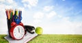 Multiple school equipment against landscape with green grass and blue sky