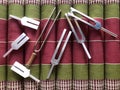 Silver Metal Tuning Forks on Green and Red Background