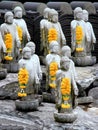 Multiple small buddha statues with yellow garlands