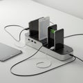 Multiple smartphones are positioned vertically on a sleek, rectangular charging station. Royalty Free Stock Photo