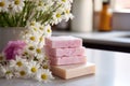 multiple soap bars stacked with fresh daisies in between on a tiled countertop