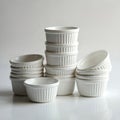 Multiple stacks of white ceramic ramekins presented in studio setting. Ideal for baking, desserts, souffle, food service, Royalty Free Stock Photo