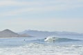 Multiple surfers riding wave off of coast landscape Baja, Mexico