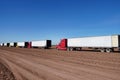 multiple trucks lined up in a harvest lot of a transport and shipping company, ready to go.