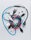 Different types of USB cables tangled together on a white surface Royalty Free Stock Photo
