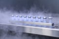 Multiple vials with cryopreserved eggs are stored in a transparent rack surrounded by vapor Royalty Free Stock Photo
