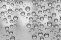 Multiple water drops or raindrops of different sizes on a window glass