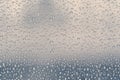 Multiple water drops or raindrops of different sizes on a window glass