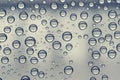 Multiple water drops or raindrops of different sizes on a window glass