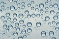 Multiple water drops or raindrops of different sizes on a window glass