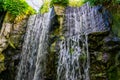 Multiple waterfalls streaming of a big rock cliff in a forest, nature background Royalty Free Stock Photo