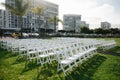 Multiple white folding chairs for event. Outdoor city wedding Royalty Free Stock Photo