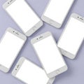 Multiple white smartphones displaying blank screens on a light purple background Royalty Free Stock Photo
