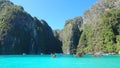 Multiple wooden long tail boats drifting around majestic limestone karsts.