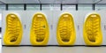 Multiple yellow and white toilets lined up in a room