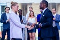 Multiracial african men handshaking at meeting and making deal shaking hands to white caucasian business woman