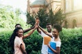 Multiracial best friends group giving high five sitting at cafe table. Happy diverse african young people join hands up together Royalty Free Stock Photo