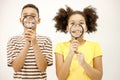 Multiracial boy and girl holding two magnifying glasses near their mouth Royalty Free Stock Photo