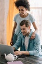 Multiracial boyfriend and girlfriend looking at laptop