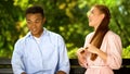 Multiracial boyfriend listening to annoying girlfriend, shocked by chatty girl