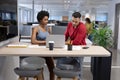 Multiracial business advisors discussing over laptop in meeting at modern workplace