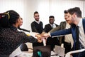 Multiracial business people standing at office and put hands on hands. Diverse group of employees in formal wear Royalty Free Stock Photo