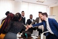 Multiracial business people standing at office and put hands on hands. Diverse group of employees in formal wear Royalty Free Stock Photo