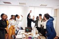 Multiracial business people standing at office and put hands up. Diverse group of employees in formal wear Royalty Free Stock Photo