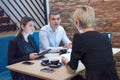 Multiracial business people working connected with technological devices at the bar. Group of three young creative coworkers Royalty Free Stock Photo