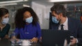 Diverse business team brainstorm together wearing protective face mask in office