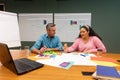 Multiracial businessman and businesswoman discussing strategy over documents in creative office Royalty Free Stock Photo