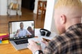 Multiracial businessmen planning strategies while video conferencing through laptop in office