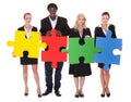 Multiracial businesspeople holding jigsaw puzzle