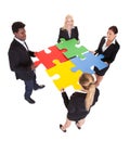 Multiracial businesspeople holding jigsaw puzzle