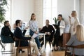 Multiracial businesspeople listening to confident young female speaker. Royalty Free Stock Photo