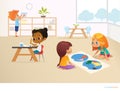 Multiracial children in Montessori classroom. Girls viewing world map