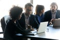 Multiracial colleagues work on laptops brainstorm at briefing Royalty Free Stock Photo