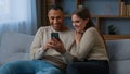 Multiracial couple african american man and hispanic woman win game on mobile phone read good news get bank loan Royalty Free Stock Photo