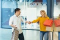 multiracial couple asian man and caucasian woman walking together in mall after shopping with colored bags in hands Royalty Free Stock Photo