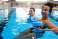 Multiracial couple attending water aerobics class in a swimming pool Royalty Free Stock Photo