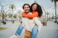 Multiracial couple embracing and having fun. Caucasian man giving his african american girlfriend a romantic piggyback Royalty Free Stock Photo