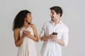 Multiracial couple expressing surprise while using cellphones