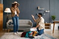 Multiracial couple packing clothes into travel suitcase