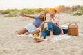 Multiracial couple smiling and gesturing during picnic on beach Royalty Free Stock Photo