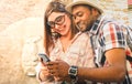 Multiracial couple using mobile smart phone at old town trip - Fun concept with alternative fashion travelers - Indian boyfriend Royalty Free Stock Photo