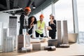 Multiracial coworkers builders and architects standing at table with blueprints Royalty Free Stock Photo