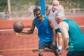 multiracial elderly men playing basketball together on playground Royalty Free Stock Photo