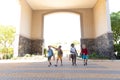 Multiracial elementary schoolboys with backpack entering school