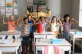 Multiracial elementary students and african american young male teacher flexing muscles